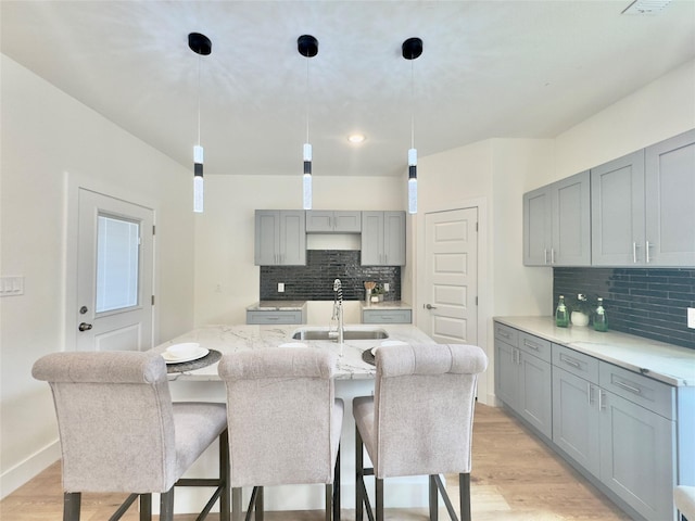 3801 Carpenter Ave, Dallas, TX 75210 - kitchen featuring gray cabinets, a sink, decorative backsplash, light wood finished floors, and recessed lighting