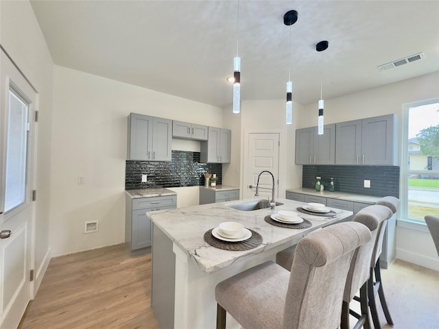3801 Carpenter Ave, Dallas, TX 75210 - kitchen featuring gray cabinets, a sink, and tasteful backsplash