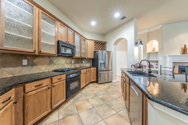 kitchen with black appliances, a sink, tasteful backsplash, dark stone counters, and recessed lighting