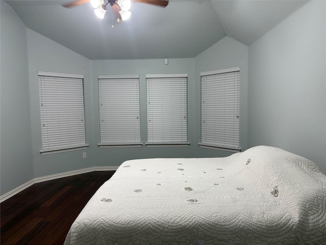 bedroom with lofted ceiling, dark wood-style flooring, baseboards, and a ceiling fan