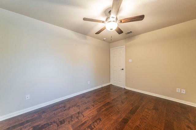 unfurnished room featuring baseboards, dark wood finished floors, and a ceiling fan