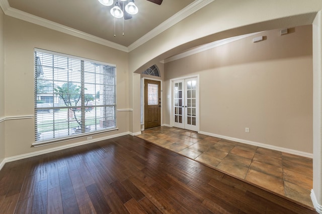 spare room featuring crown molding, french doors, arched walkways, a ceiling fan, and healthy amount of natural light