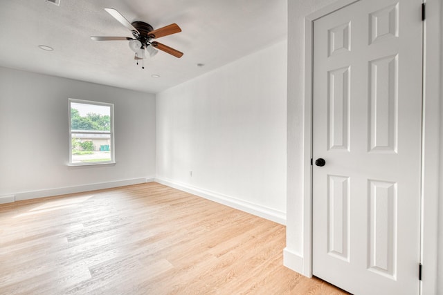 empty room with light wood-style flooring, baseboards, and a ceiling fan