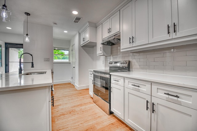 kitchen featuring stainless steel electric range, under cabinet range hood, a sink, baseboards, and light wood finished floors