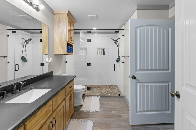 677 County Road 4027, Savoy, TX 75479 - bathroom featuring a stall shower, vanity, wood finished floors, and toilet
