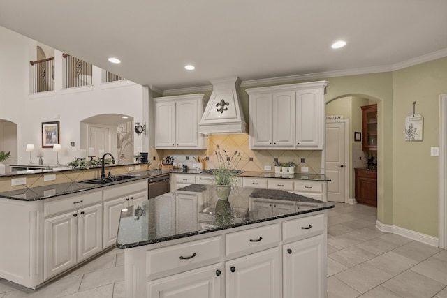 3002 Spring Hill Ln, Highland Village, TX 75077 - kitchen featuring a sink, custom exhaust hood, dishwashing machine, arched walkways, and a kitchen island