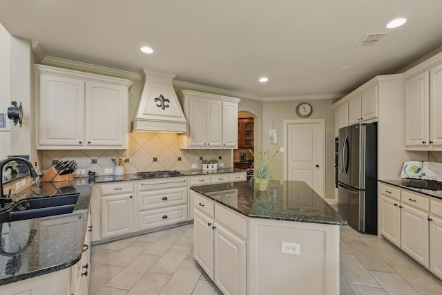 3002 Spring Hill Ln, Highland Village, TX 75077 - kitchen with appliances with stainless steel finishes, a sink, custom exhaust hood, light tile patterned floors, and arched walkways