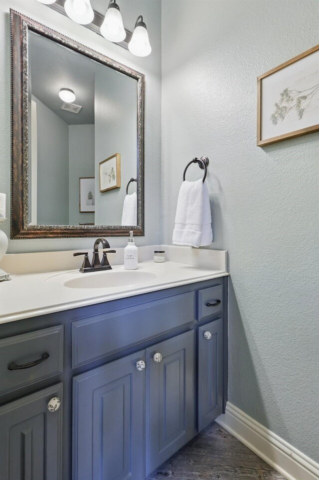3002 Spring Hill Ln, Highland Village, TX 75077 - bathroom with vanity, wood finished floors, baseboards, and a textured wall
