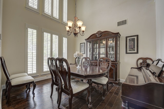 4205 English Ivy Dr, Mckinney, TX 75070 - dining area featuring a towering ceiling, a chandelier, baseboards, and dark wood-type flooring