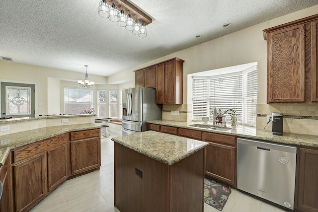 4205 English Ivy Dr, Mckinney, TX 75070 - kitchen featuring appliances with stainless steel finishes, a sink, a textured ceiling, a chandelier, and backsplash