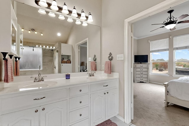 ensuite bathroom with double vanity, ceiling fan, a shower, ornamental molding, and baseboards