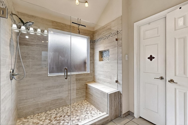 bathroom with lofted ceiling, a stall shower, and tile patterned floors