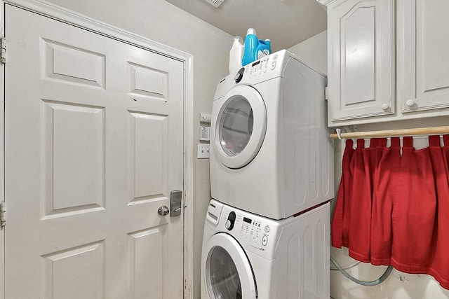 washroom featuring stacked washer / drying machine