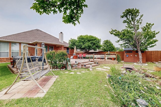 view of yard with a deck, an outdoor structure, and a shed