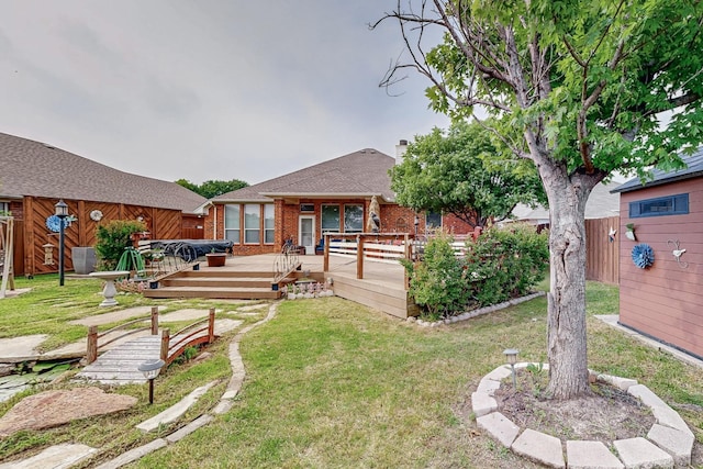 rear view of house featuring a wooden deck, brick siding, and roof with shingles