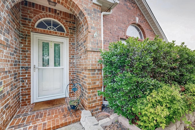 view of exterior entry with brick siding