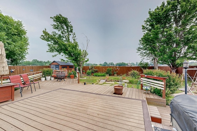 wooden terrace with a fenced backyard and an outdoor structure