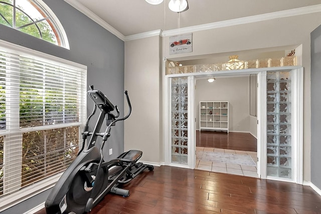workout room featuring ornamental molding, hardwood / wood-style flooring, and baseboards