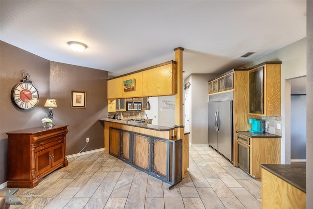 109 Fry Blvd, Tuscola, TX 79562 - kitchen with stainless steel appliances, a peninsula, dark countertops, a sink, and baseboards