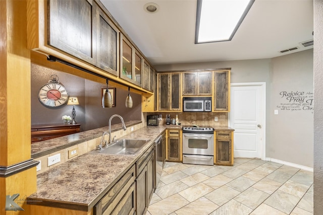 109 Fry Blvd, Tuscola, TX 79562 - kitchen with appliances with stainless steel finishes, a sink, decorative backsplash, baseboards, and glass insert cabinets
