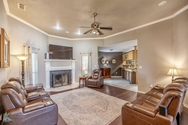 109 Fry Blvd, Tuscola, TX 79562 - living room with ceiling fan, light wood-style flooring, a fireplace, crown molding, and baseboards