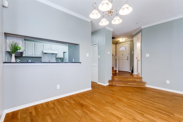 6000 Auburndale Ave Unit E, University Park, TX 75205 - kitchen with under cabinet range hood, a chandelier, dark countertops, light wood-type flooring, and baseboards