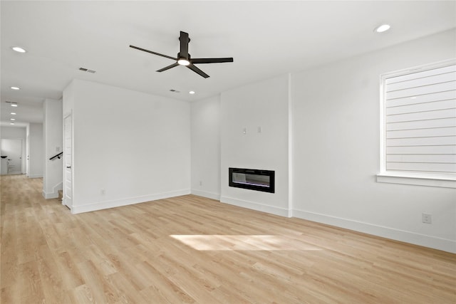 2534 Pennsylvania Ave, Dallas, TX 75215 - unfurnished living room featuring light wood-type flooring, recessed lighting, a glass covered fireplace, a ceiling fan, and baseboards