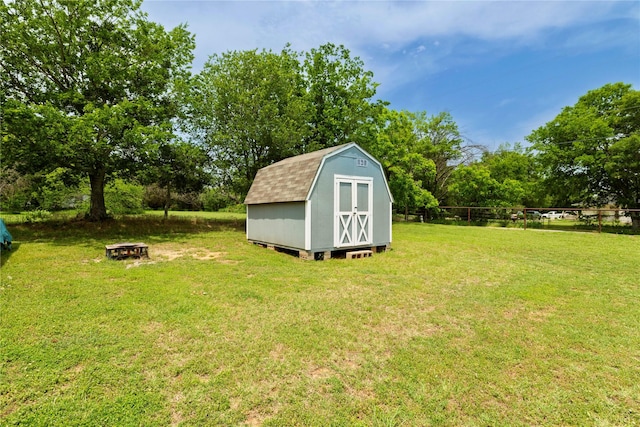 140 Pine Rd, Poolville, TX 76487 - view of green lawn featuring a storage unit, an outdoor structure, an outdoor fire pit, and view of scattered trees