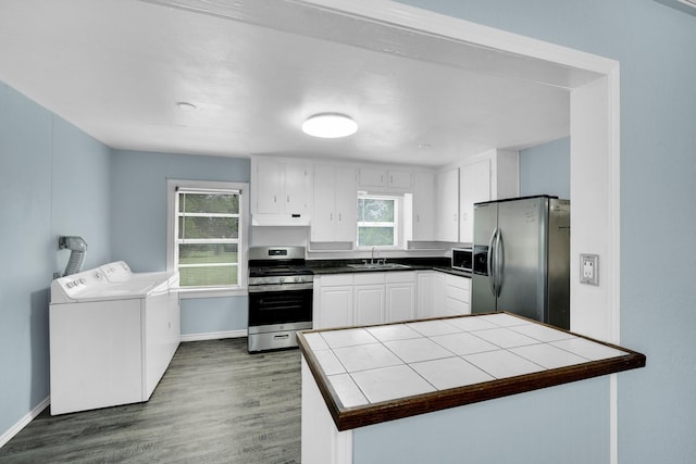 121 Chowning Dr, Desoto, TX 75115 - kitchen featuring stainless steel appliances, separate washer and dryer, a sink, under cabinet range hood, and dark wood finished floors