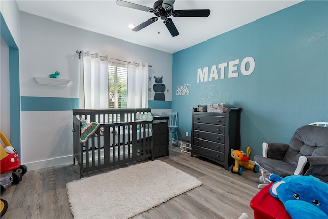 203 Mcelroy St, Southmayd, TX 76273 - bedroom with wood finished floors, a nursery area, a ceiling fan, and baseboards