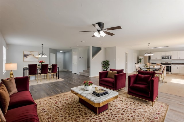 8537 Star Thistle Dr, Fort Worth, TX 76179 - living room featuring a chandelier, stairway, light wood-type flooring, and a ceiling fan