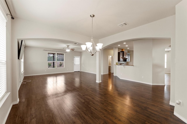 5541 Wisdom Ct, Waco, TX 76708 - unfurnished living room with ceiling fan, dark wood-style flooring, arched walkways, baseboards, and a chandelier