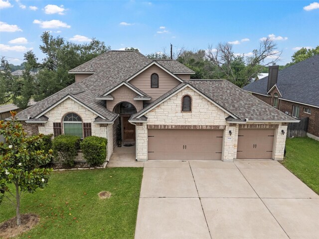 5541 Wisdom Ct, Waco, TX 76708 - french country style house featuring roof with shingles, driveway, an attached garage, and stone siding