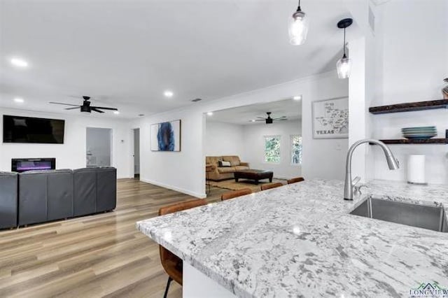 228 Stuart Dr, Karnack, TX 75661 - kitchen featuring ceiling fan, a sink, open floor plan, light stone countertops, and recessed lighting