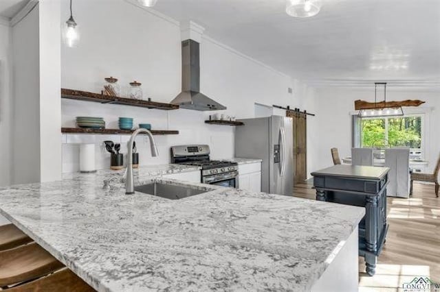 228 Stuart Dr, Karnack, TX 75661 - kitchen with stainless steel appliances, wall chimney range hood, a barn door, a sink, and open shelves