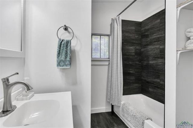 228 Stuart Dr, Karnack, TX 75661 - full bath featuring a sink, a shower with shower curtain, baseboards, and wood finished floors