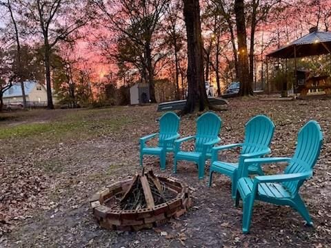 228 Stuart Dr, Karnack, TX 75661 - view of yard featuring an outdoor fire pit, a shed, and an outdoor structure