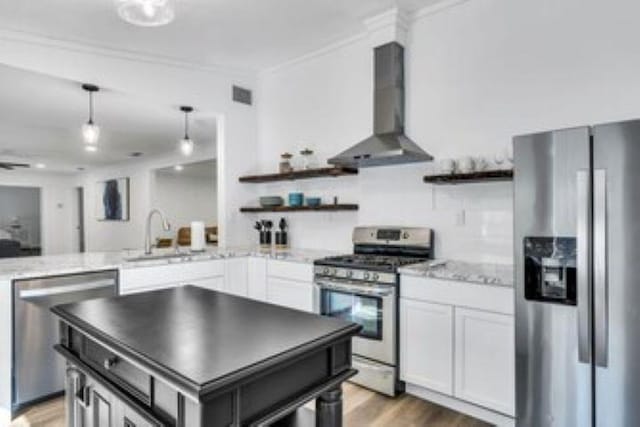228 Stuart Dr, Karnack, TX 75661 - kitchen featuring stainless steel appliances, wall chimney exhaust hood, open shelves, crown molding, and a sink