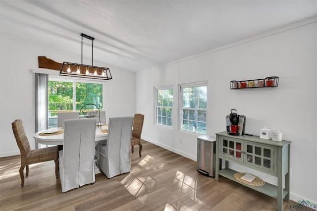 228 Stuart Dr, Karnack, TX 75661 - dining area with healthy amount of natural light, wood finished floors, baseboards, ornamental molding, and a chandelier