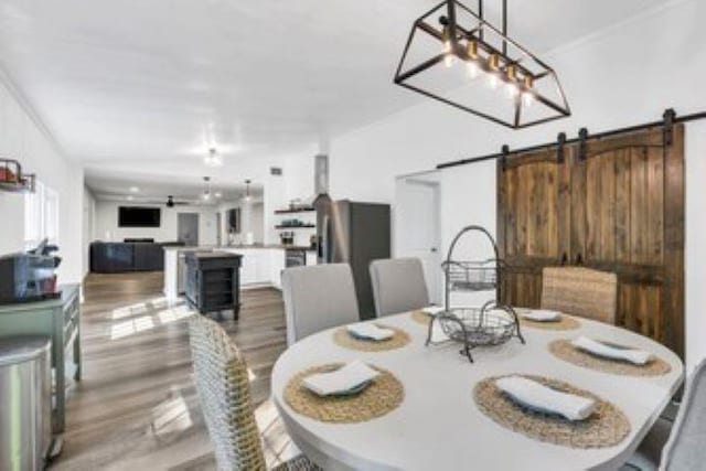228 Stuart Dr, Karnack, TX 75661 - dining room featuring a barn door and wood finished floors