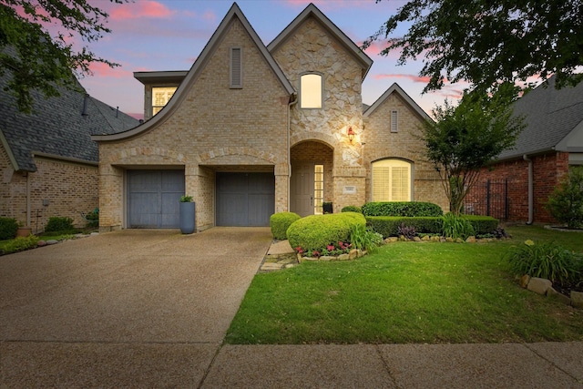 5581 Travis Dr, Frisco, TX 75034 - french country home with concrete driveway, a garage, stone siding, and brick siding