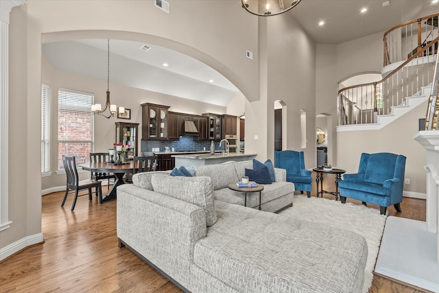 5581 Travis Dr, Frisco, TX 75034 - living room with a chandelier, light wood-type flooring, baseboards, stairway, and recessed lighting