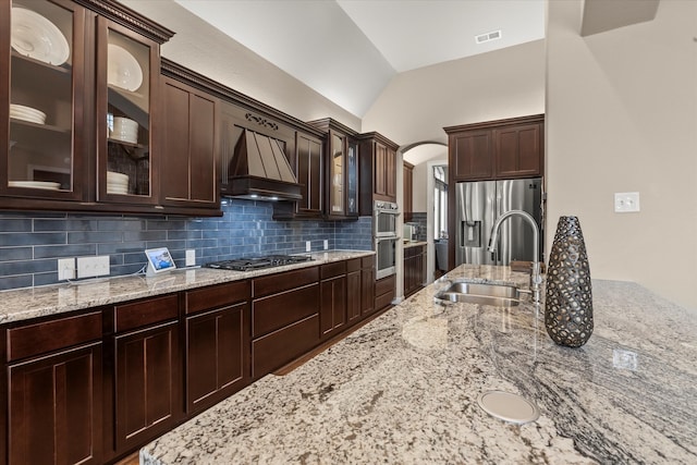 5581 Travis Dr, Frisco, TX 75034 - kitchen featuring premium range hood, a sink, backsplash, dark brown cabinets, and stainless steel appliances