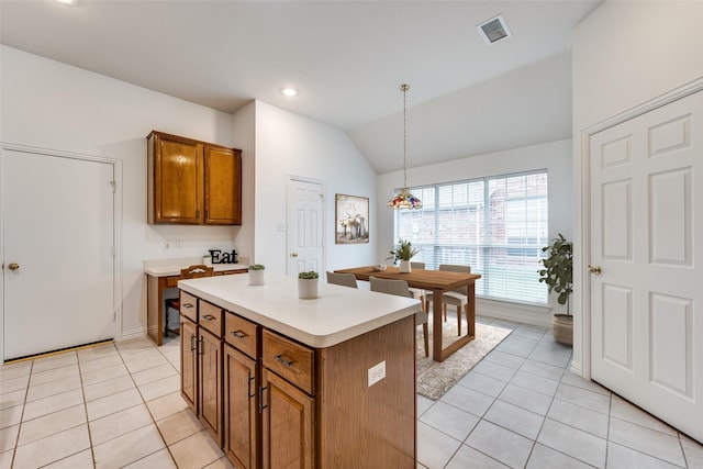 7002 Westover Dr, Rowlett, TX 75089 - kitchen featuring brown cabinets, light tile patterned floors, light countertops, lofted ceiling, and a kitchen island