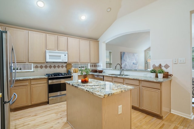 4525 Crooked Ridge Dr, The Colony, TX 75056 - kitchen featuring appliances with stainless steel finishes, a sink, light brown cabinets, vaulted ceiling, and a kitchen island