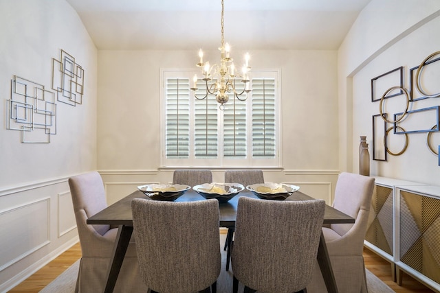 4525 Crooked Ridge Dr, The Colony, TX 75056 - dining space featuring a chandelier, wood finished floors, a decorative wall, and wainscoting