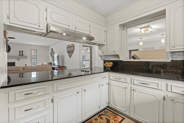 1247 Wedgewood Dr, Cleburne, TX 76033 - kitchen with black electric cooktop, under cabinet range hood, white cabinets, and a brick fireplace