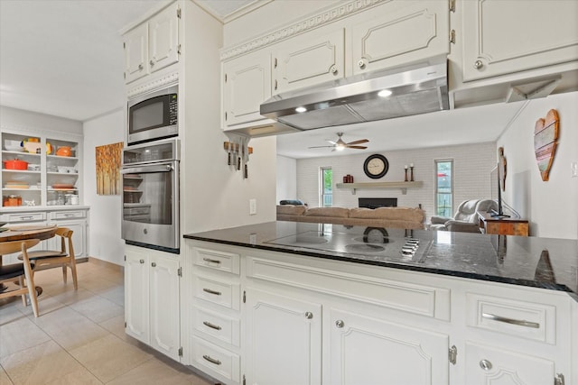 1247 Wedgewood Dr, Cleburne, TX 76033 - kitchen featuring appliances with stainless steel finishes, a ceiling fan, under cabinet range hood, light tile patterned floors, and white cabinetry