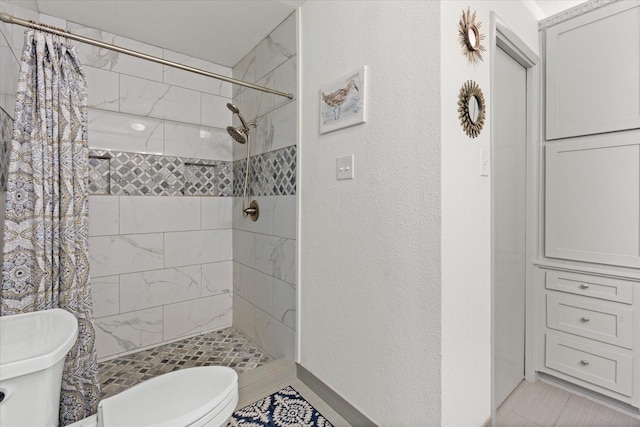 1247 Wedgewood Dr, Cleburne, TX 76033 - full bathroom featuring toilet, a shower stall, and a textured wall