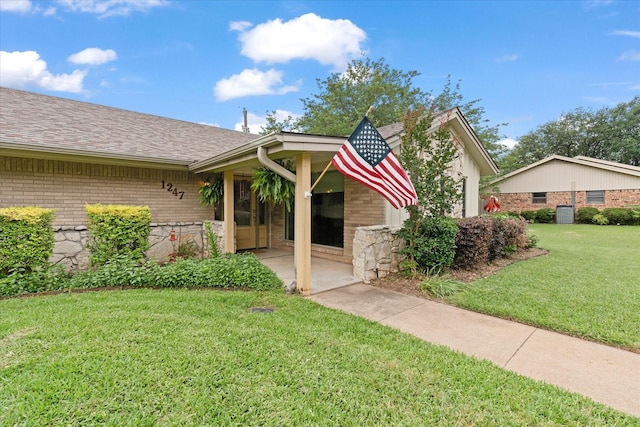 1247 Wedgewood Dr, Cleburne, TX 76033 - view of front of property with brick siding, a front lawn, a shingled roof, and a porch